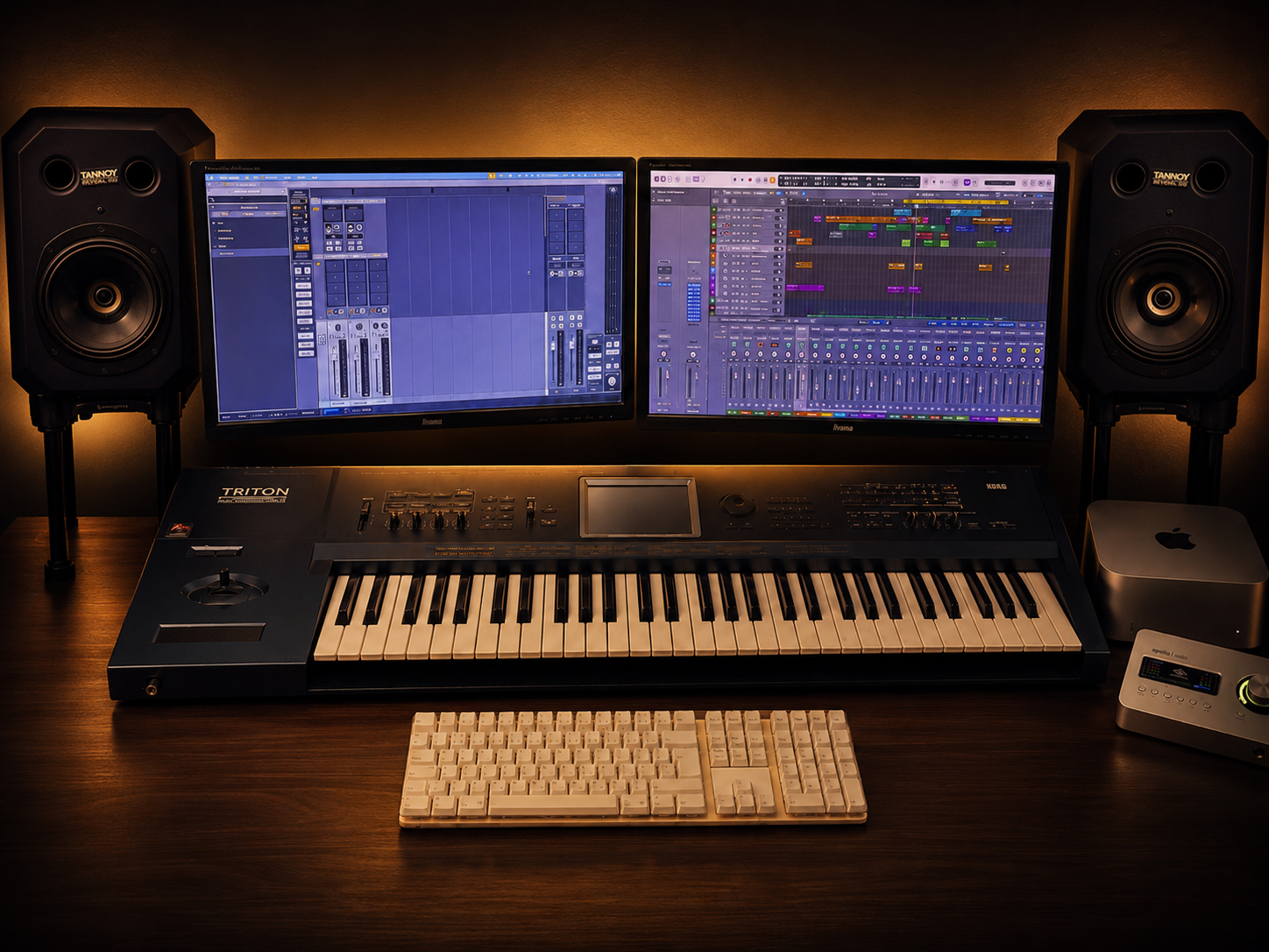 Professional workstation with dual Iiyama displays, Tannoy speakers, Korg Triton workstation, Mac Studio, keyboard and Apollo Solo.